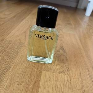 Säljer en klassisk Versace L'Homme Eau de Toilette. Flaskan är stilren och elegant med en genomskinlig glasdesign och svart spraykork. Perfekt för den som vill ha en tidlös och maskulin doft. Passar både till vardags och fest!