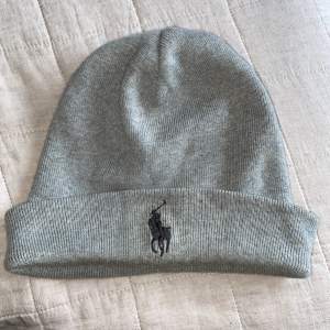 Grå Polo Ralph Lauren mössa i ljus grå.  Den är lite missfärgat på insidan och utsidan dock är det inte jätte synligt.