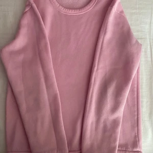 Rosa fleece tröja - Säljer en supermjuk och mysig rosa fleece tröja. Perfekt för kyliga dagar och att mysa i hemma. Tröjan har långa ärmar och en rund halsringning. Den är i bra skick och redo för en ny ägare! 💖