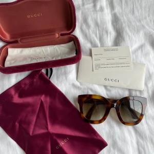 Oanvända Gucci solglasögon 0208S 003 - Äkta gucci solglasögon i nyskick. Inga repor etc. Använda 3-4ggr, men passar inte min ansiktsform. Form: cateye. Färg: havana. Bågbredd 145mm, brygga 28mm, gladhöjd 48mm, glasbredd 49mm, skalmlängd 140mm. Allt på bilden medföljer. Nypris 4270kr