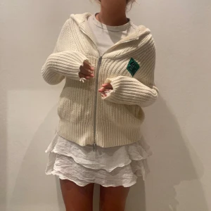 Zip-up ZADIG hoodie - Superskön krämvit stickad zip-up kofta med luva från Zadig&Voltaire. Cool grönglittrig logga på bröstet💚Köpt på Zadig’s hemsida för ca 4 år sen men bara använt 2 gånger så den är i väldigt bra skick!