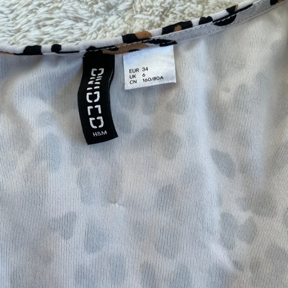 Säljer en supercool leopardmönstrad byxsdress från Divided H&M. Den har en v-ringad design och korta ärmar, perfekt för en avslappnad men ändå stilren look. Klänningen är i storlek XS och har en elastisk midja för en bekväm passform. Perfekt för en dag ute eller en festkväll! 🐆✨. Övrigt.