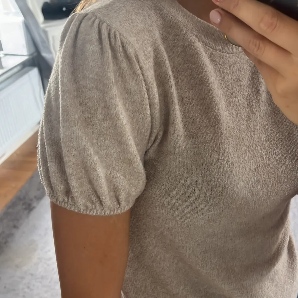 En beige stickad T-shirt med puffärmar från zara i storlek S,men jag skulle säga att den är liten i storleken. Den är jätteskön och trendig . Stickat.