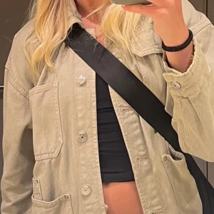 Beige overshirt från Pull&Bear - Säljer denna gröna jacka från pull and bear. Supersnygg och knappt använd!! Stl M men passar xs-m⭐️