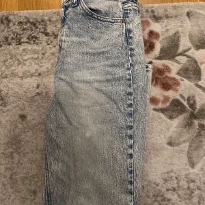 Blå jeans från H&M - Snygga blå jeans med en klassisk design. De har en hög midja och en rak passform som ger en tidlös look. Perfekta för en avslappnad stil.