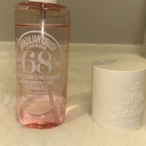 Brazilian Crush Cheirosa 68 - En doftspray med noter av brasiliansk jasmin och rosa drakfrukt. Flaskan är genomskinlig med rosa vätska och har en vit kork med präglad text. Perfekt för att ge en fräsch och exotisk känsla. Använt ett par gånger men skulle nästan säga att den är helt ny. Flaskan är 240 ml, på parfym butikerna säljs den för 450.