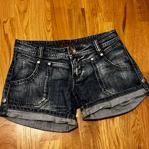 Jeansshorts från Fishbone - Snygga jeansshorts från Fishbone i en klassisk blå tvätt. De har en lågmidjad design med fem fickor och knappstängning. Perfekta för en avslappnad stil.