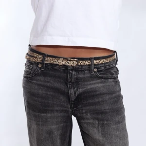 Leopardmönstrat bälte - Snyggt leopardmönstrat bälte som ger en cool touch till din outfit. Perfekt för att liva upp jeans eller en enkel klänning. Bältet har en smal design och ett klassiskt spänne.
