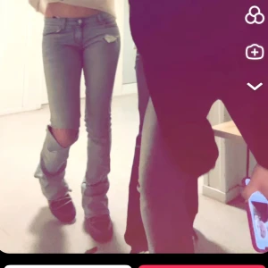 Blå jeans med slitna detaljer - Snygga blå jeans med slitna detaljer vid knäna. De har en låg midja och en bootcut-stil som ger en avslappnad look. Perfekta för en trendig outfit.