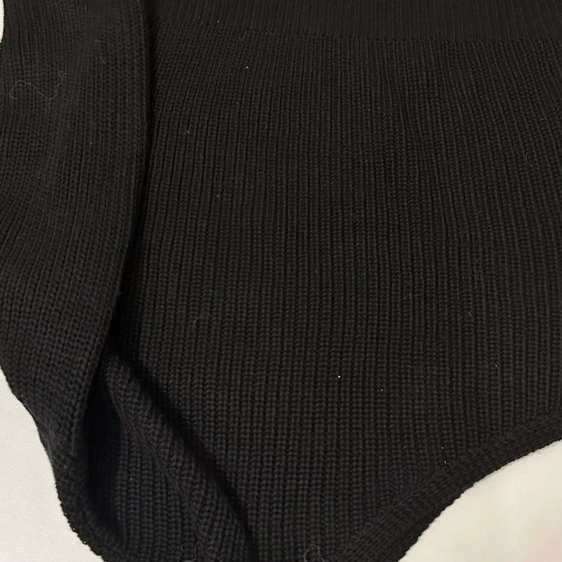 Svart stickad med en arm - 1
