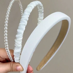 Tre vita diadem med olika detaljer - Säljer tre stilrena vita diadem. Ett med pärlor, ett med rynkad satin, och ett enkelt brett diadem i satin. Säljer antingen 1 för 15kr eller alla tre för 30kr 😊