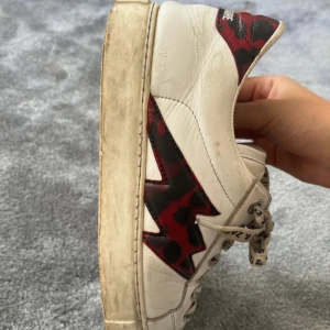 Vita sneakers från Zadig & Voltaire - Snygga vita sneakers med leopardmönstrade detaljer i rött och svart från Zadig & Voltaire. De har några defekter, de sista 2 bilderna. Men det är varken något som syns eller känns. Box och dustbag medföljer. Nypris är 4000