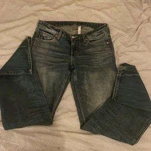 Low Waist blue jeans - Snygga blå jeans med en cool slitningseffekt. De har en klassisk femficksdesign och knappgylf. Det ser ut som nya! 