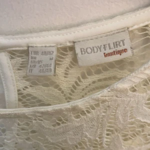 Vit spetsklänning från Bodyflirt - Elegant vit spetsklänning från Bodyflirt med långa ärmar och ett vackert mönster. Klänningen har en rund hals och en lätt utställd kjol som ger en fin silhuett. Perfekt för speciella tillfällen.priset kan diskuteras 