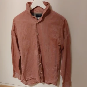 Rosa skjorta från Jack & Jones - Snygg rosa skjorta från Jack & Jones i ett mjukt material. Skjortan har långa ärmar och knappar framtill. Perfekt för en stilren look.