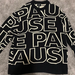 Tröja från H&M - Säljer en svart tröja från H&M med stora vita bokstäver som bildar ordet 'PAUSE'. Tröjan har en avslappnad passform och långa ärmar. Perfekt för en cool och avslappnad stil. Kan kännas lite som oversize!