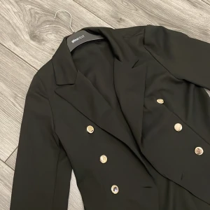 Elegant svart blazer från Zara - En snygg svart blazer med guldiga knappar, tunn i tyget o passar perfekt året om. Knappt använd och köpt på Zara. 