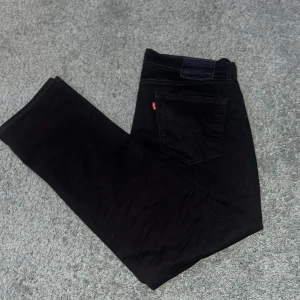  Levi's 514 - Snygga svarta jeansbyxor från Levi's med klassisk femficksdesign och knappgylf. Perfekta för en stilren look. Passar till många olika tillfällen och stilar.