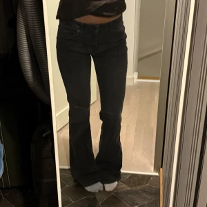 Svarta bootcut jeans - Snygga svarta bootcut jeans med låg midja. Perfekta för en avslappnad stil. De har en klassisk design med fickor och dragkedja. Från bershka i storlek 34.