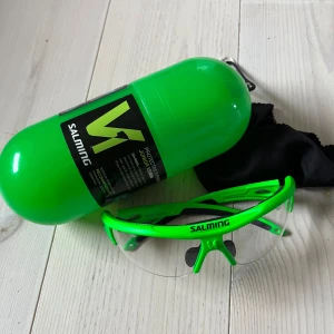 Gröna sportglasögon från Salming junior - Snygga och funktionella sportglasögon från Salming för barn med en grön ram och transparenta linser. Perfekta för träning och andra sportaktiviteter. Kommer med ett praktiskt fodral för säker förvaring.