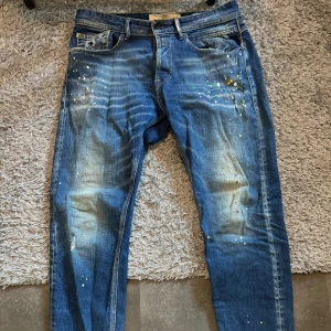 Replay jeans med färgstänk  - Blåa replay jeans med färg stänk i storlek 32x30, är i bra skick och säljes för dom blivit för små.  Satt bra på mig vid 78kg o 180 lång 