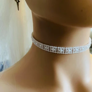 Made by prisförslag- Vit pärlchoker - Elegant vit choker dekorerad med små pärlor i ett vackert mönster. Perfekt för att ge en stilren touch till din outfit. Passar bra till både vardag och festliga tillfällen.