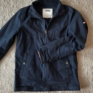 Windbreaker från Tommy jeans! - Säljer en stilren marinblå jacka från Tommy Jeans. Perfekta vårjackan för dig som är runt 178cm lång. 
