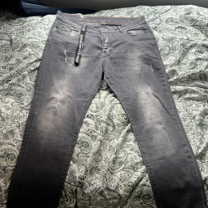 Grå jeans från Dsquared2 - Snygga grå jeans från Dsquared2 med en cool slitningseffekt. De har en klassisk femficksdesign och en knappgylf. Perfekta för en trendig look.