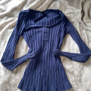 Ribbad tröja med knappar  - Långärmad ribbad tröja med knappar (går att knäppa upp). 