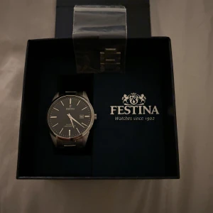 Festina Klocka - Snygg och stilren klocka från Festina i silverfärg. Den har en klassisk design med en rund urtavla och metallarmband. Levereras i originalförpackning med extra länkar!