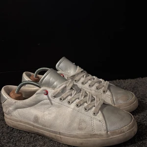 Vita sneakers med snörning - Snygga vita sneakers med snörning och diskreta röda detaljer. Perfekta för en avslappnad stil. Skorna har en klassisk design med rund tå och platt sula.