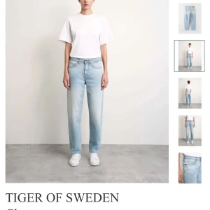 Ljusblå jeans från Tiger of Sweden - Snygga ljusblå jeans modell ”Cleva”  från Tiger of Sweden i en klassisk straight fit. De har en normal passform och är tillverkade i Italien. Perfekta för en stilren look. Jeans med normal passform Fem-ficks stil Medel hög midja Tvätten heter "Craze" Märkesknapp och nitar Jacron-logolapp i midjan 99% Ekologisk Bomull 1% Elastan  