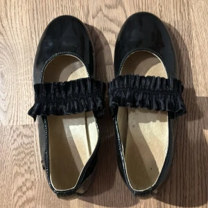 Svarta lackade ballerinaskor med volangdetalj ( Natarina) - Orginal price = 150O kr / New price = 500 kr    Storlek = 33 