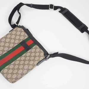 Gucci GG Supreme Web Flat Messenger Bag - Beige/ebony GG Supreme canvas Black leather trim Interior zipper and smartphone pockets Adjustable nylon shoulder strap with 58cm drop and leather shoulder pad Made in Italy Black nylon lining  Storlek: W21cm X H22cm x D4cm 