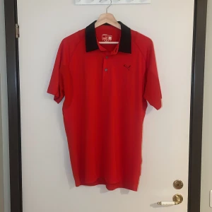 Röd pikétröja från Puma - Säljer en snygg röd pikétröja från Puma i mycket bra skick. Den har en svart krage och knappar framtill. Perfekt för både vardag och sportiga aktiviteter. Passar bra till jeans eller shorts för en avslappnad look. Pris går alltid att förhandlas!