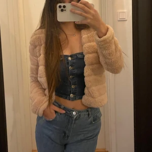 Beige teddyjacka Gina - Säljer en supermjuk och gosig beige teddyjacka. Perfekt för att hålla sig varm och snygg under kyliga dagar. Jackan har en croppad stil och långa ärmar, vilket gör den både trendig och bekväm. Passar perfekt till både jeans och klänning!