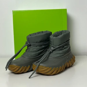 Crocs Echo Boots 42/43 dusty olive - Upplev det bästa av båda världar med Crocs Echo Boots – designade för att ge både komfort hela dagen och en trendig, uttrycksfull stil. Med ett varmt foder och en puffig ovandel i nylon håller de dina fötter bekvämt varma och gör dig redo för avslappnade dagar i stan eller på landet. Croslite-sulan ger en mjuk och responsiv känsla i varje steg, medan yttersulan med rejält gummigrepp låter dig röra dig tryggt på alla typer av underlag  • Puffig ovandel i nylon • Mjukt, värmande foder • Justerbar 