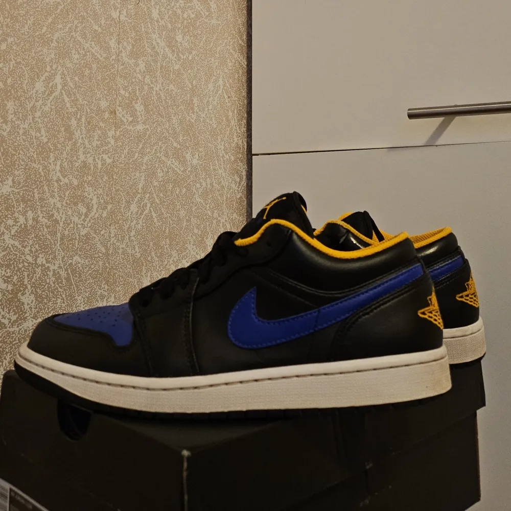 Säljer ett par Nike Air Jordans i svart och blått med gula detaljer. Skorna är i nytt skick och kommer i originalkartong. Perfekta för både vardag och fest med sin snygga design och bekväma passform. Storlek och mer info finns vid intresse!. Skor.