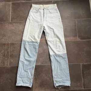 Ljusblå jeans med två olika nyanser - Ljusblå jeans med en patchwork-design med två olika jeanstyger i storlek 36. Highwaist och straight leg. Längd 108 cm, innerbenslängd 82 cm & midja 37 cm