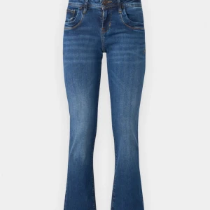 Blå ltb bootcut jeans - Snygga blå bootcut jeans från Ltb med klassisk femficksdesign. De har en bekväm passform och är perfekta för en avslappnad stil. Jeansen har en lätt tvättad look. Jeansen är köpta för 869kr på Zalando och är i bra skick, däremot är jeansen lite uttöjda på vissa ställen men inget man tänker på när man har de på sig.   