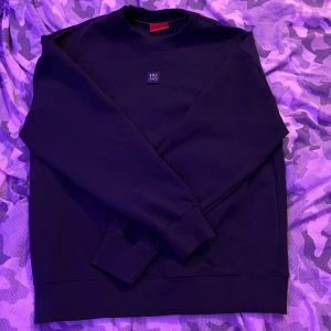 Hugo boss hoodie  - Säljer en stilren svart sweatshirt från Hugo med en diskret logotyp på bröstet. Tröjan har en klassisk rund halsringning och långa ärmar. Perfekt för en avslappnad look.