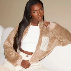 Beige teddy kofta med dragkedja och ficka - Aldrig använd mysig beige teddy kofta med dragkedja och hög krage. Koftan har en praktisk bröstficka med dragkedja och är croppad för en trendig look. 