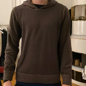Brun hoodie från Gran Sasso - Stickad, brun hoodie från Gran Sasso i storlek 50. Det är italienska storlekar. Detta innebär att plagget passar bäst på den som i normala fall har storlek medium.