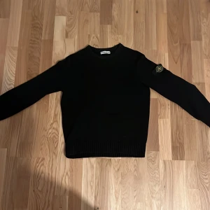 Stone island tröja - Snygg svart tröja från Stone Island med deras ikoniska märke på ärmen. Perfekt för en stilren look. Tröjan har långa ärmar och ribbade kanter jag är 180 cm och den passar bra! osäker på autenticiteten. Pris kan diskuteras! 