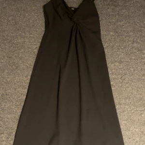 Svart långklänning - Elegant svart långklänning med en vacker drapering framtill. Klänningen har en smickrande passform och är perfekt för speciella tillfällen. Lappen är bort klippt så vet inte vart den är ifrån elr vilken storlek men passformen är S elr XS så båda skulle funka❤️ Aldrig använt men fick den av en släkting som heller aldrig använt❤️