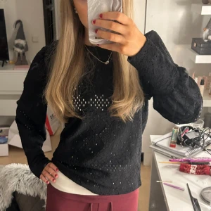 Svart tröja med hålmönster - Snygg svart tröja med hålmönster och långa ärmar. Perfekt för en stilren look. Tröjan har en normal passform. Endast använd ett fåtal gånger och har inga defekter alls!! Köpt på nelly
