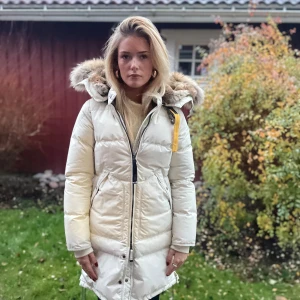 Vit dunjacka från Parajumpers - Säljer en snygg vit dunjacka från Parajumper med superfin pälshuva. Jackan/kappan är sparsamt använd endast 1 vinter och är kemtvättad till försäljning . Lång modell superskön till kalla vinterdagar. Jättefint skick.  Nypris 10 000kr  Finns på flera sidor.