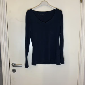 Mörkblå långärmad tröja från Tommy Hilfiger - Säljer en stilren mörkblå långärmad tröja från Tommy Hilfiger. Tröjan har en v-ringad hals och är perfekt för en avslappnad look. Passar bra till jeans eller kjol. Perfekt för höst och vår!
