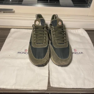 Gröna sneakers från Moncler - Snygga gröna sneakers från Moncler med snörning och en kombination av mocka och syntetmaterial. Skorna har en klassisk design med Moncler-logotypen på plösen och en bekväm sula.