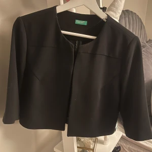 Svart bolero - Elegant svart bolero med trekvartsärm och en stilren design. Jag har sytt ett stygn så den inte ska vara helt öppen, men går lätt att sprätta upp utan att den förstörs🩷 Använd ett fåtal gånger med inga defekter. Passar stl 34/36/38!